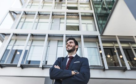 Empresário sorridente em frente a prédio moderno representando oportunidades em imóveis comerciais em São Francisco